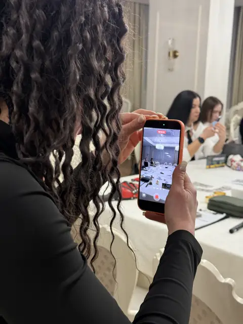 Гостя знімає на телефон атмосферу гри «Фітнес-мафія» у ресторані Black Sea