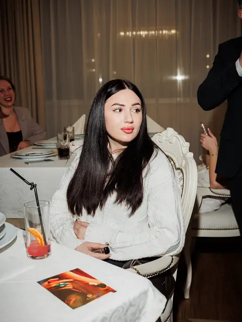 Дівчина за сервірованим столом на вечорі 8 Березня