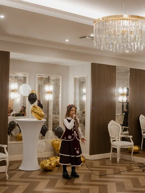 Дівчинка співає на сцені Black Sea Restaurant: дитячий звітний концерт