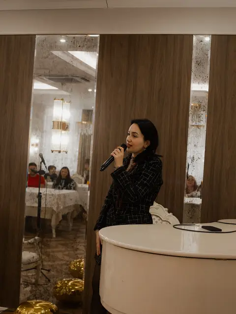 Виступ ведучої біля білого рояля у Black Sea Restaurant під час концерту