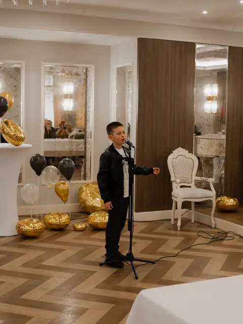 Хлопчик виконує пісню на сцені Black Sea Restaurant, дитячий звітний концерт