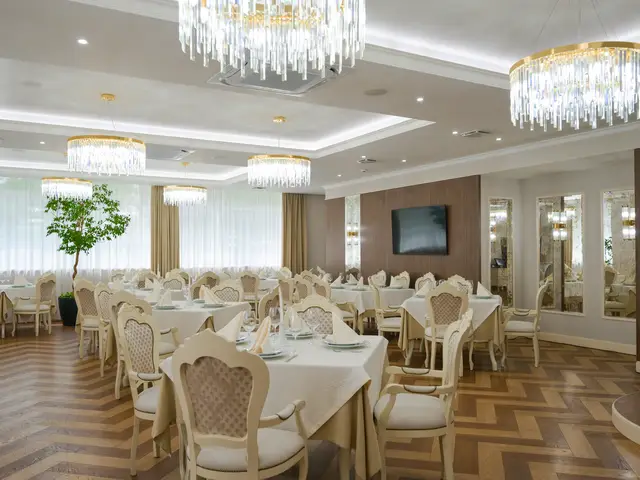 Зал с хрустальными люстрами и сервированными столами